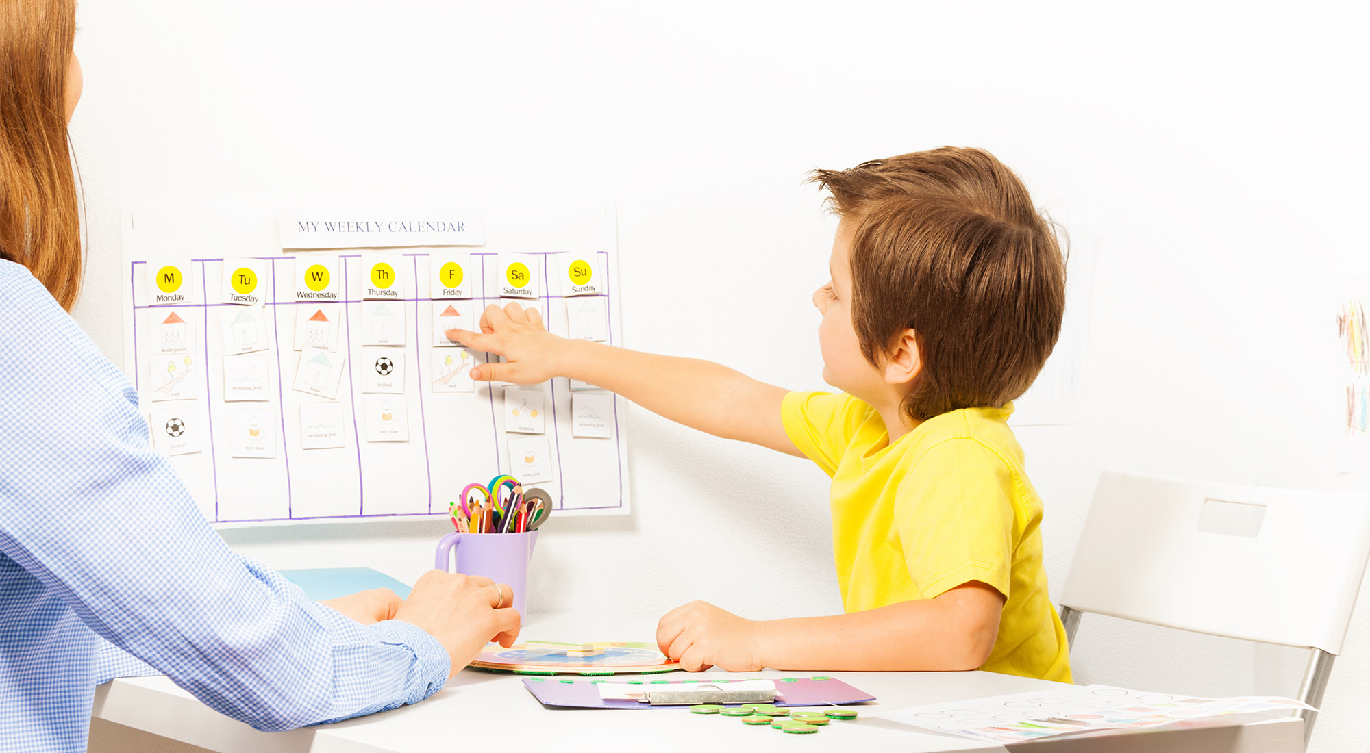 Parent discussing an ABA therapy schedule with a behavioral therapist