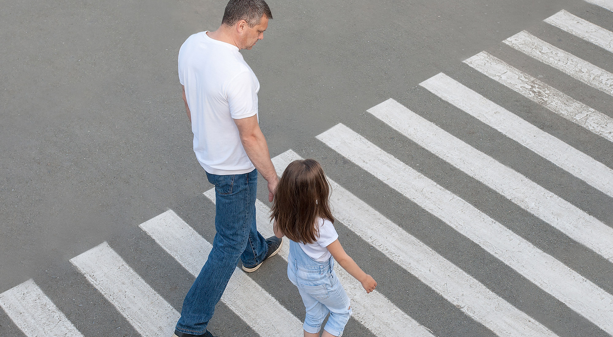 Child practicing street safety skills with parent support